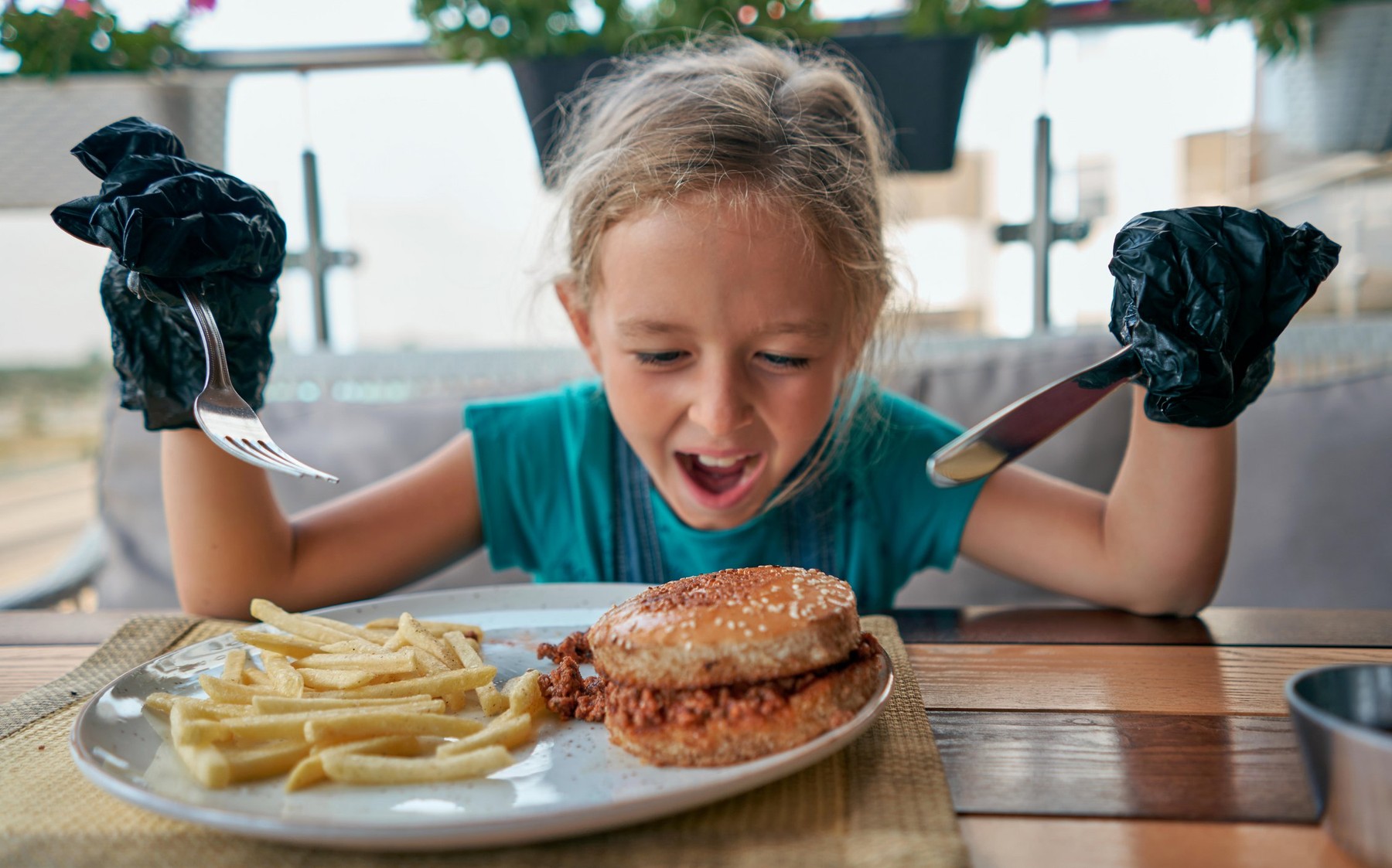 child eats a Burger in a restaurant