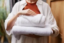 Žena nese vyprané bílé ručníky