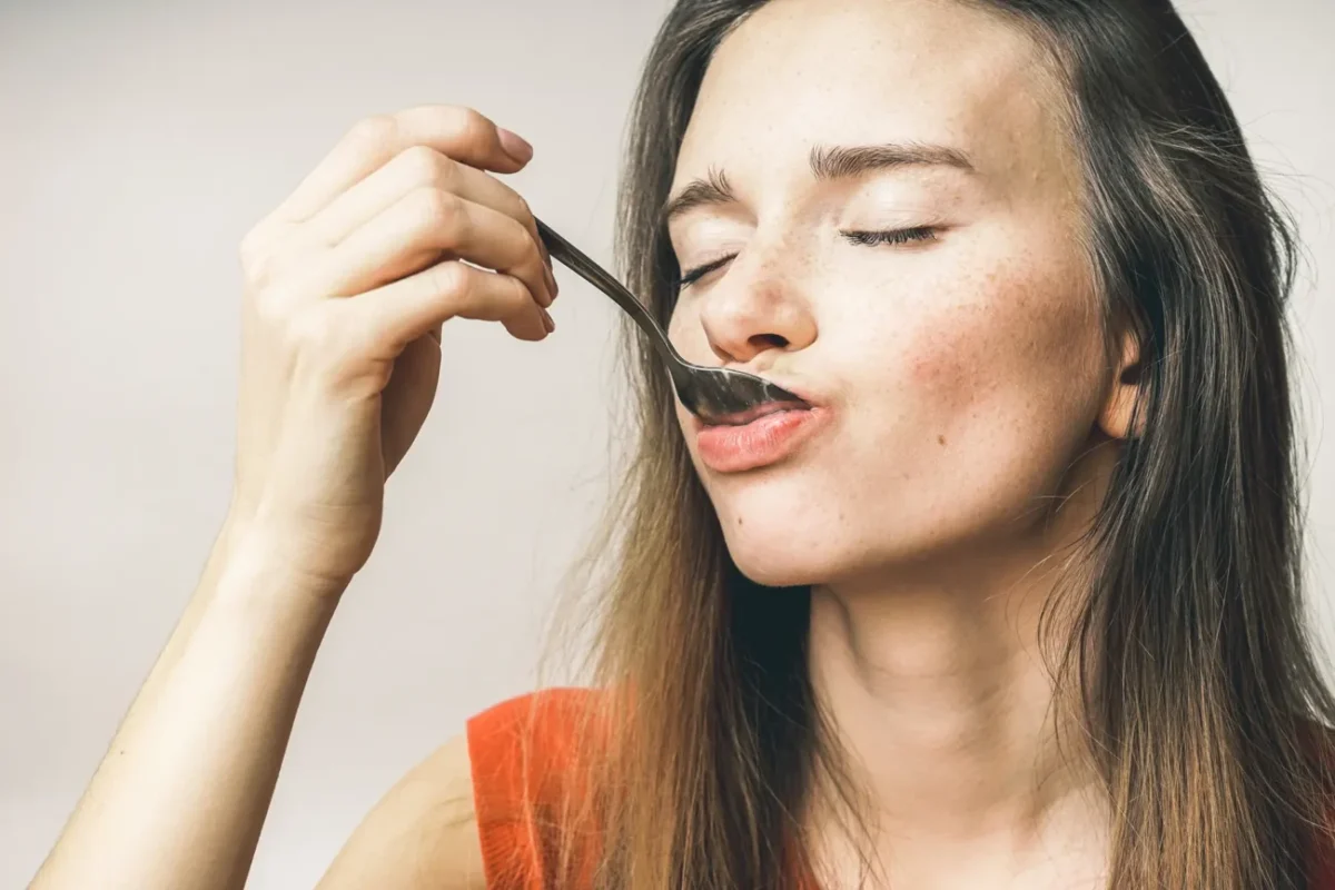 žena dává lžičku do úst