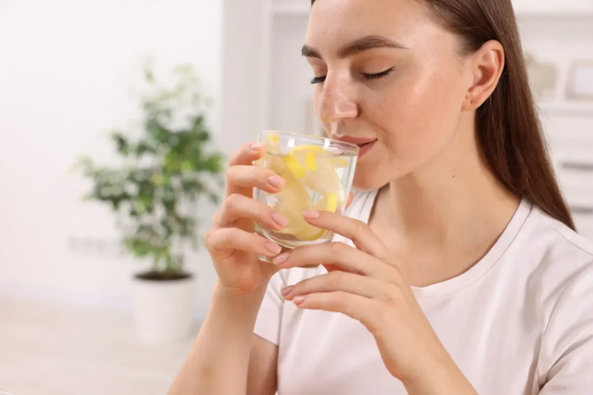 žena pije vodu s citronem