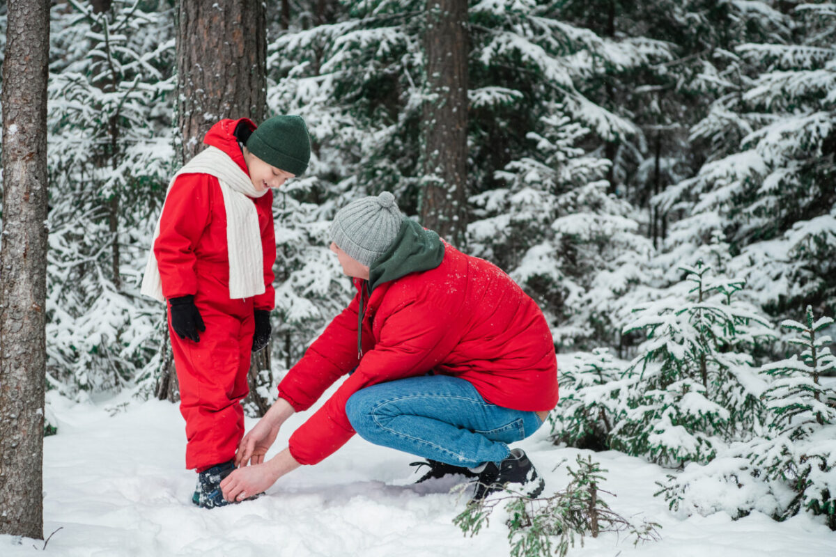 Muž zavazuje tkaničky svému dítěti.