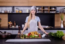 Mladá žena v kuchyni. Před ní je jídlo a lahvička s olejem.