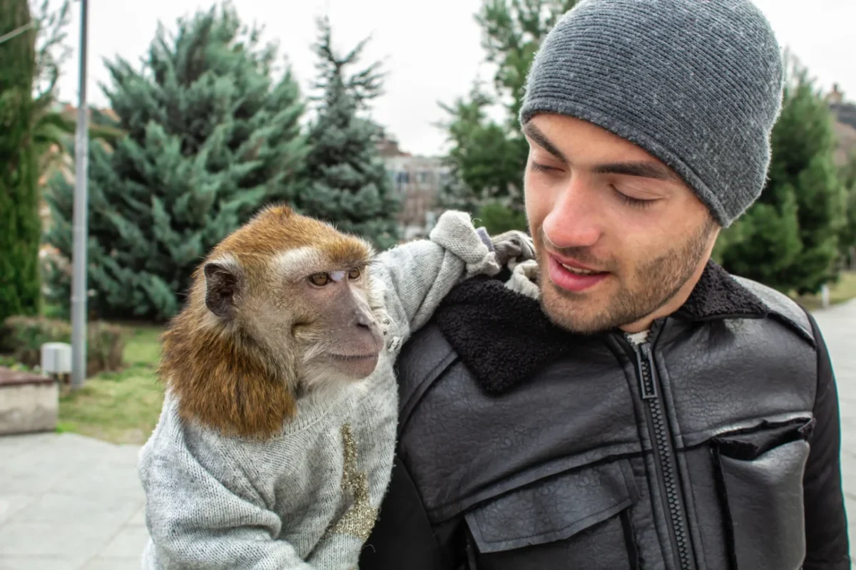 muž s opicí na ramenou