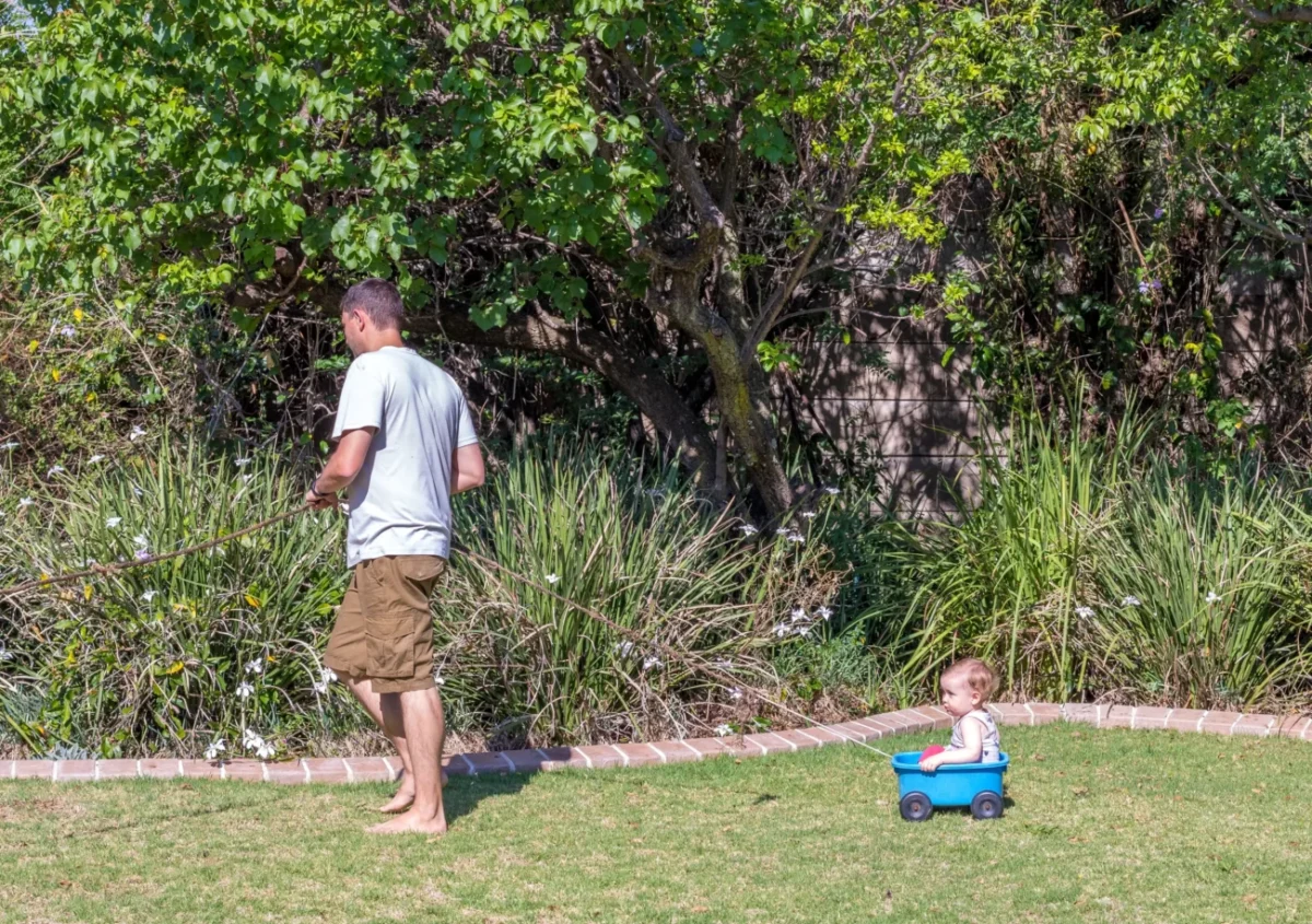 muž na zahradě s dítětem