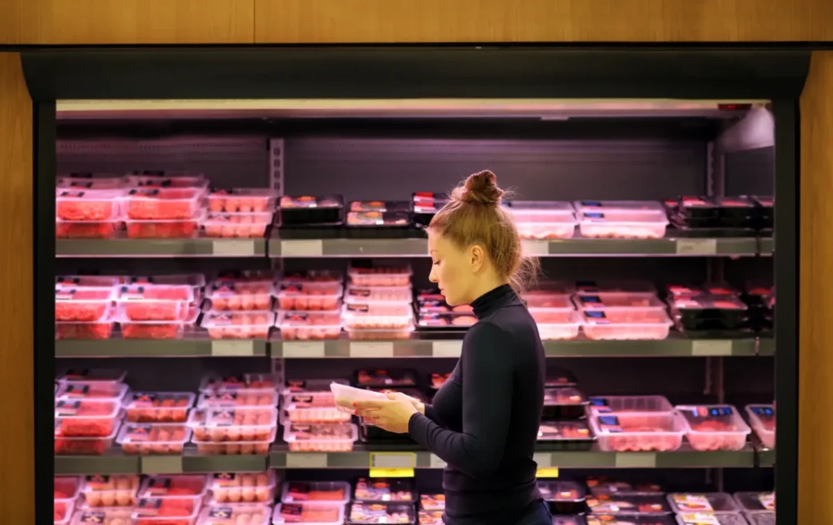 žena vybírá maso v obchodě