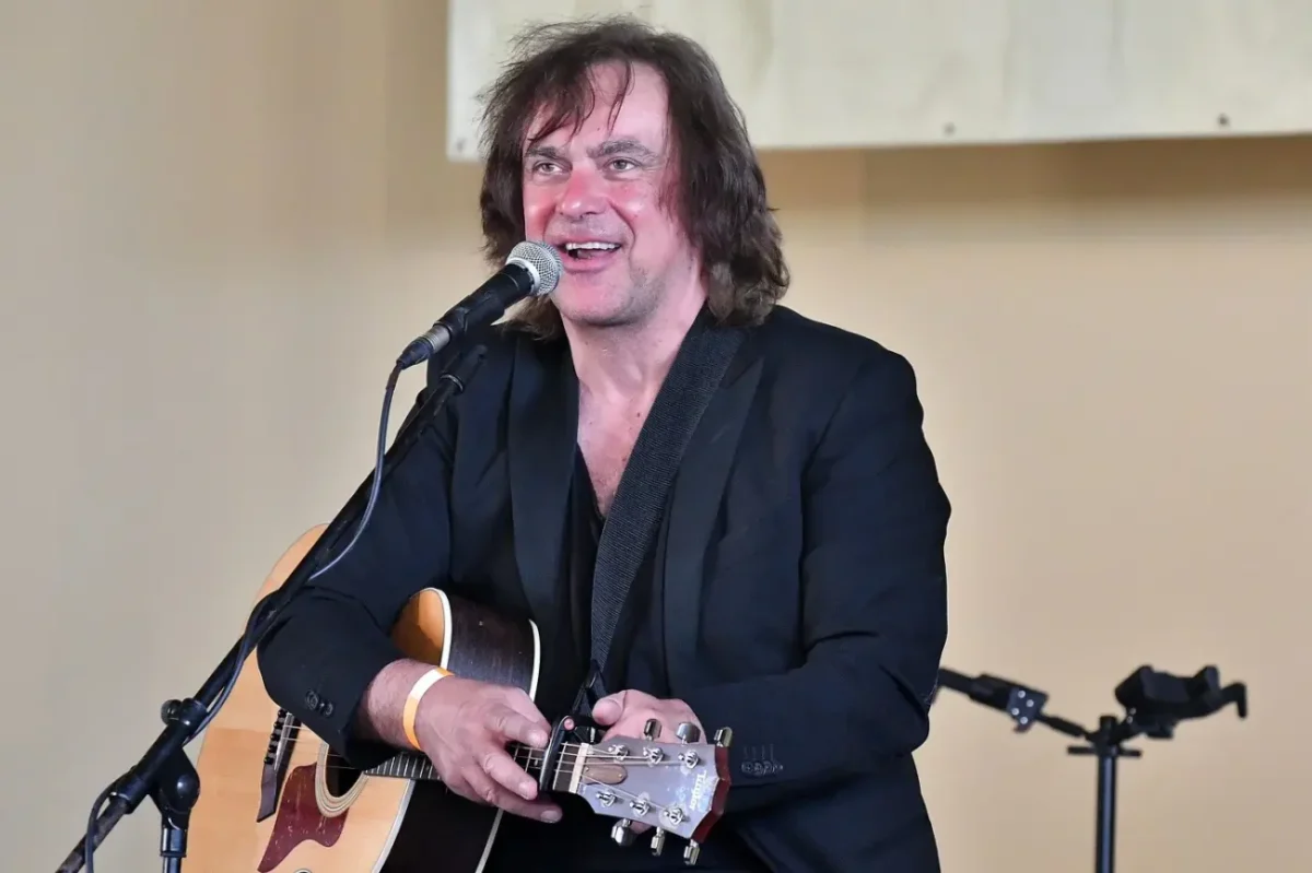 herec Tomáš Matonoha hraje na podiu na kytaru