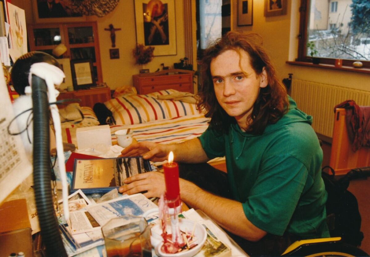 herec Jan Potměšil sedí na vozíčku u stolu