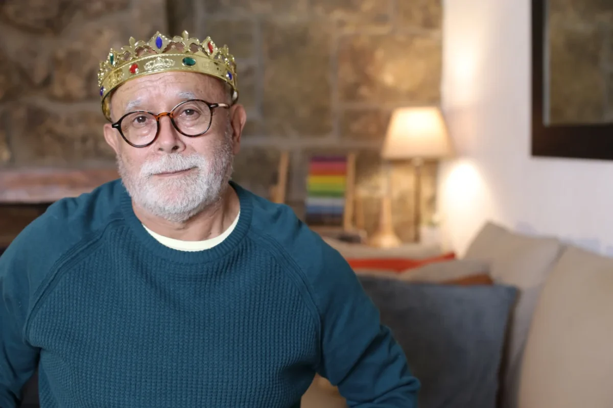 Starý muž sedí a na hlavě má korunu.