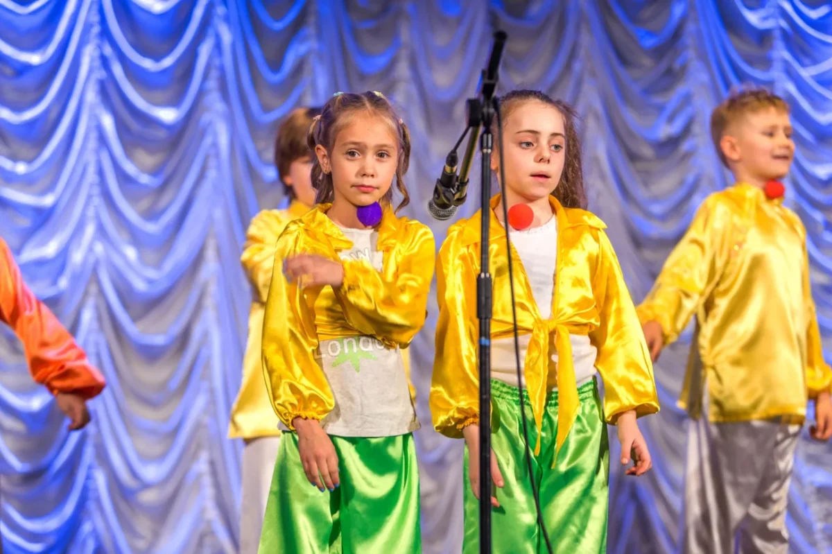 Děti zpívají na pódiu.