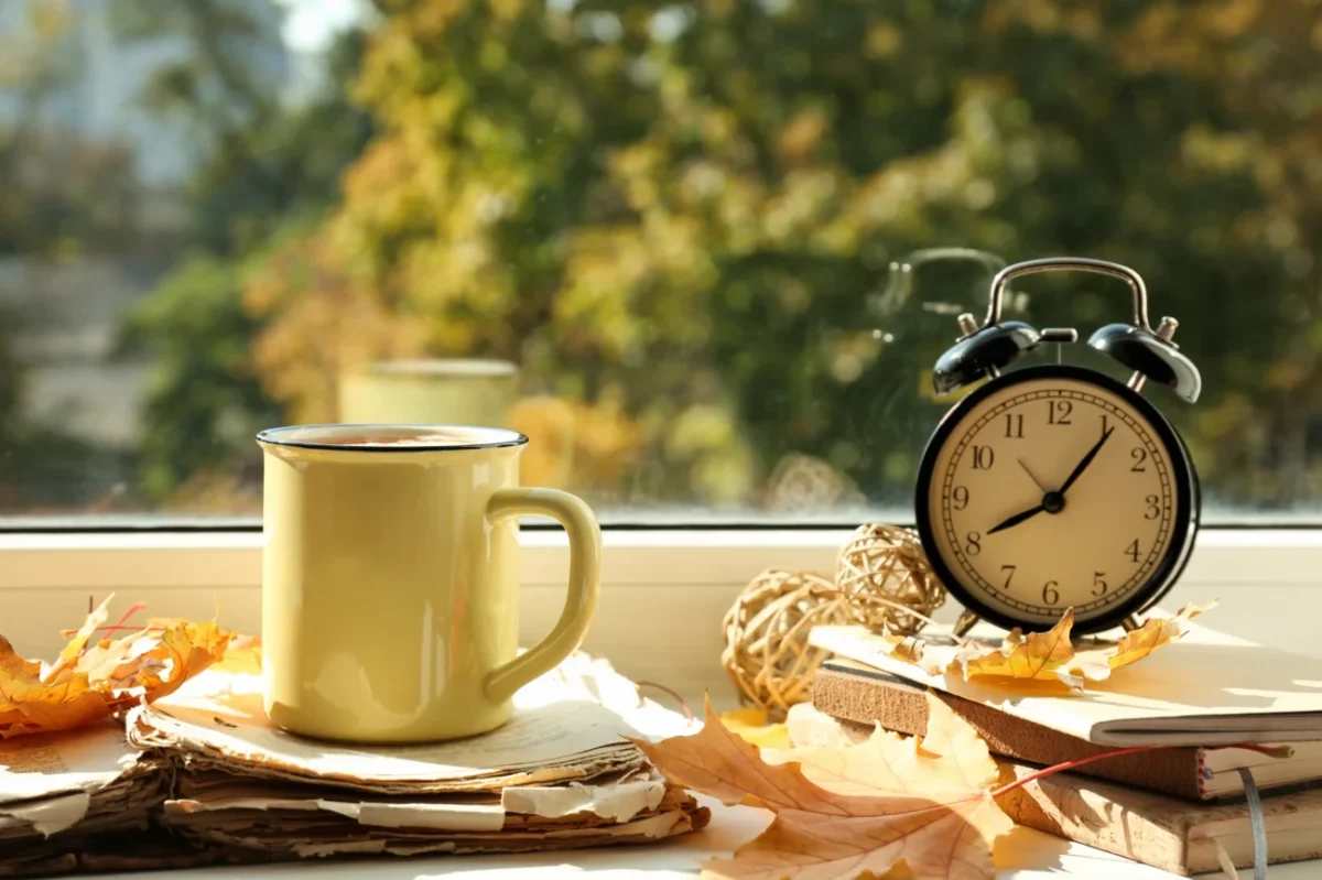 budík, hrnek, výhled do zahrady = zátiší evokující kouzlo domova, vzpomínky na dětství