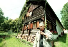 Vlastimil Brodský stojí před svojí chalupou.