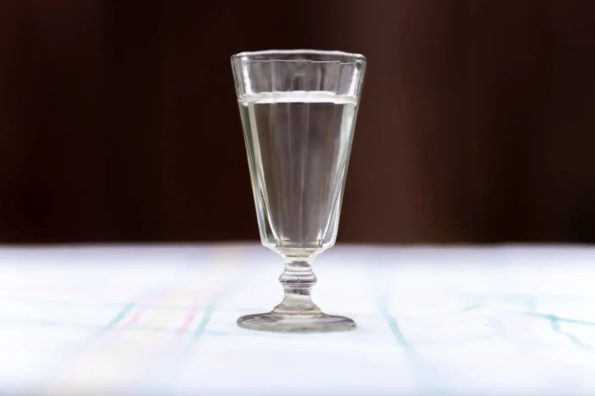 retro sklenice plná vody na stole s ubrusem