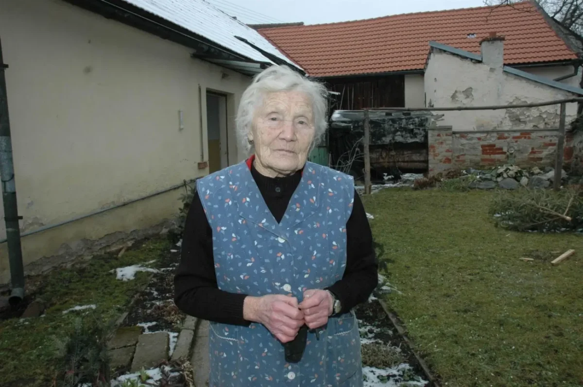 Marie Pilátová stojící na dvorku.