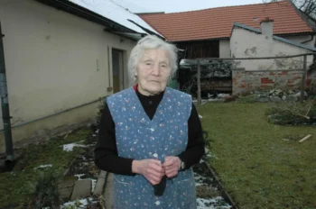 Marie Pilátová stojící na dvorku.