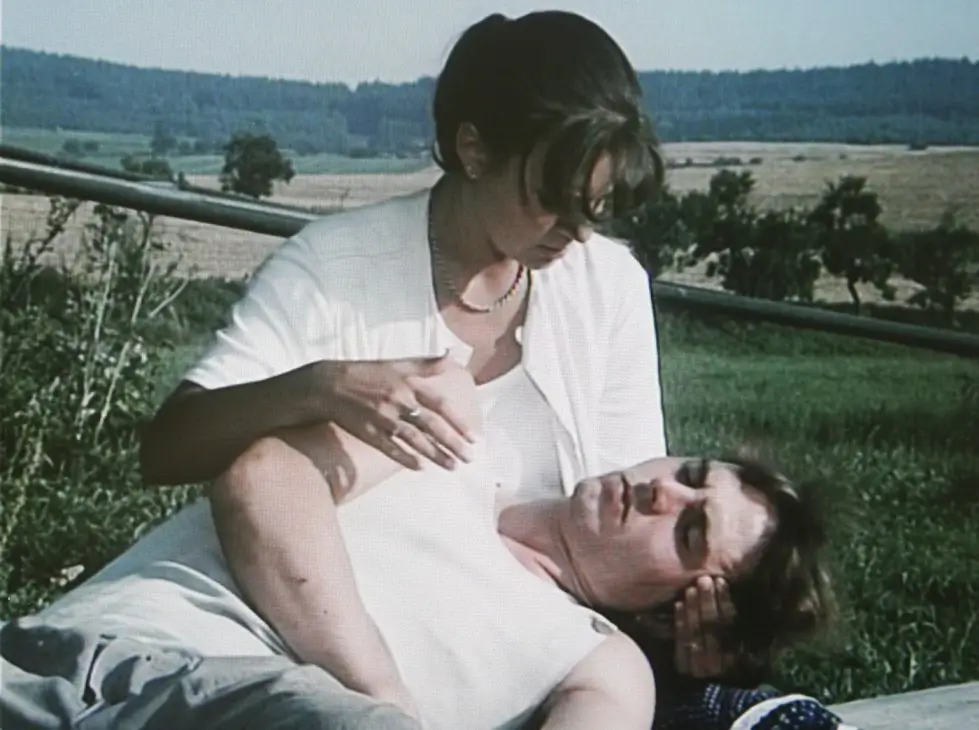 Dvě vedlejší postavy z filmu Slunce, seno sedí na louce.