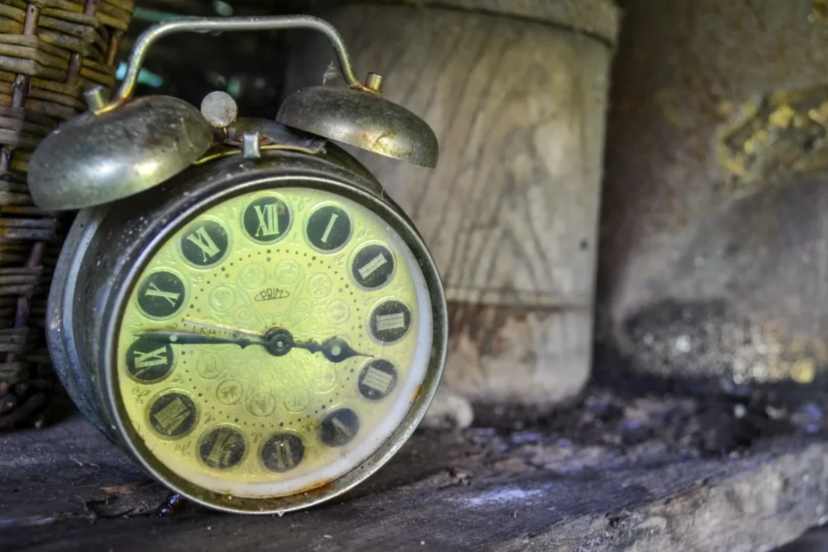 Starý budík na dřevě.