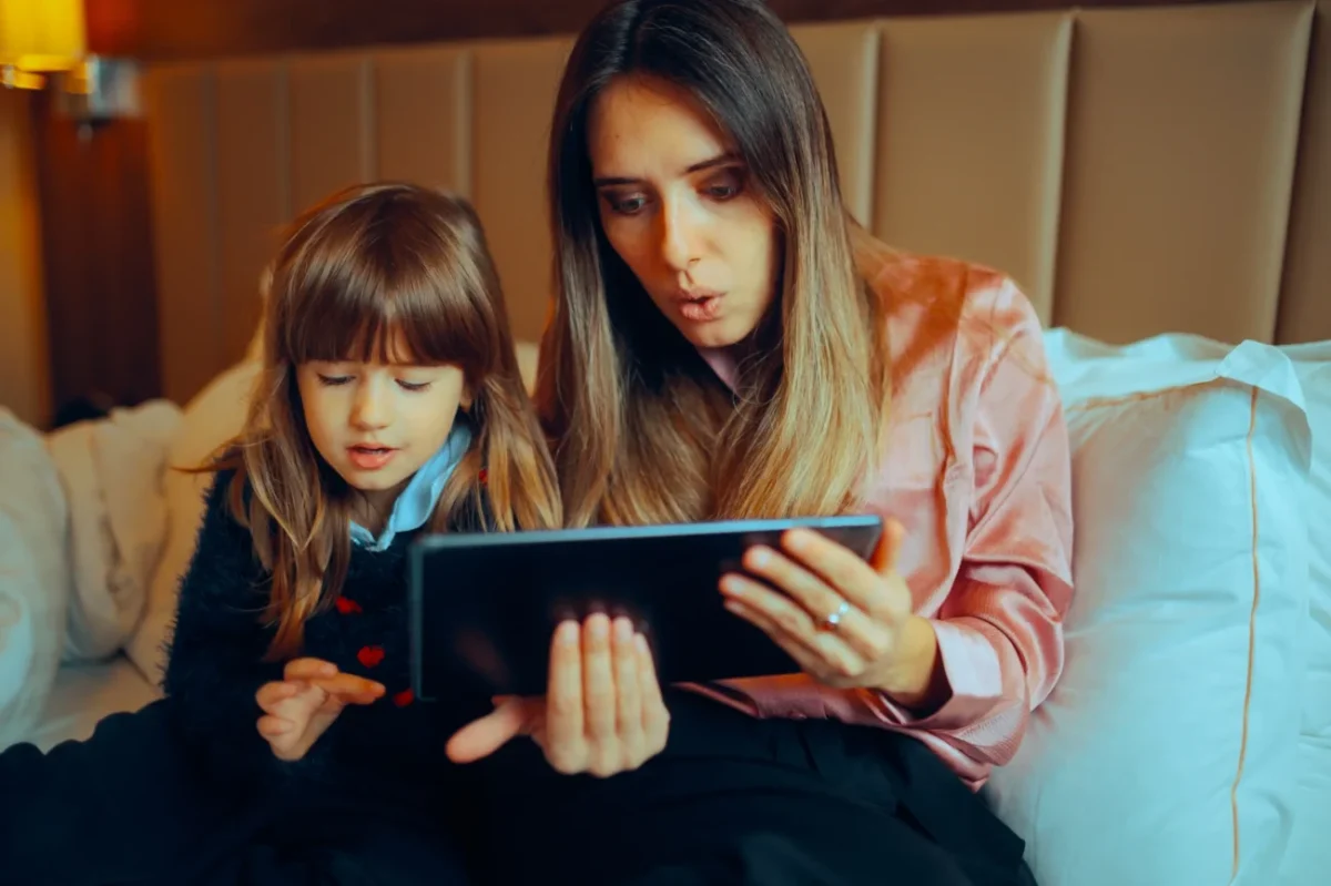 Maminka se s holčičkou kouká do tabletu.