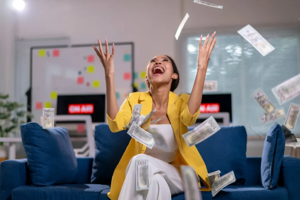Žena radující se z peněz, které létají kolem ní.