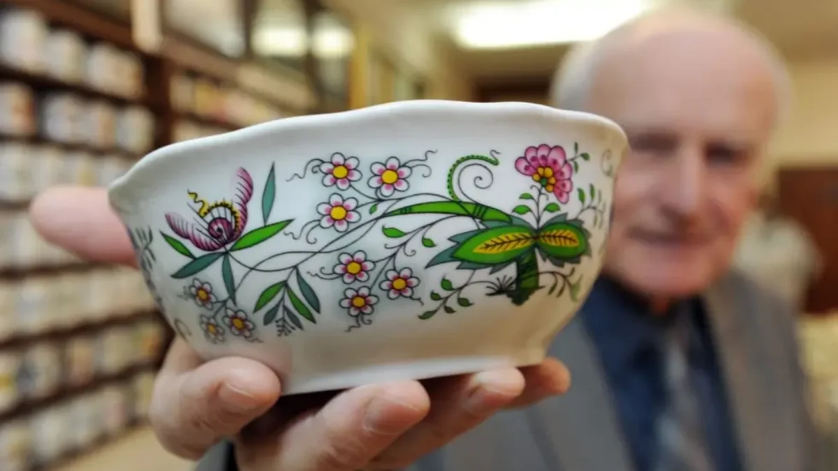 Muž ukazující porcelán z minulého století.