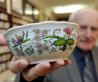 Muž ukazující porcelán z minulého století.