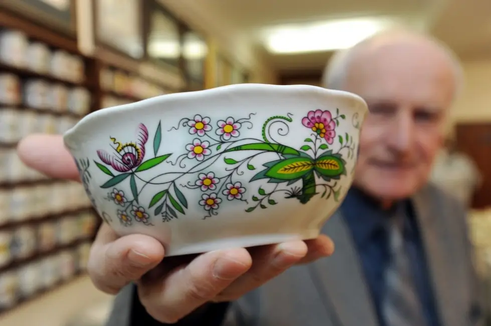 Muž ukazující porcelán z minulého století.