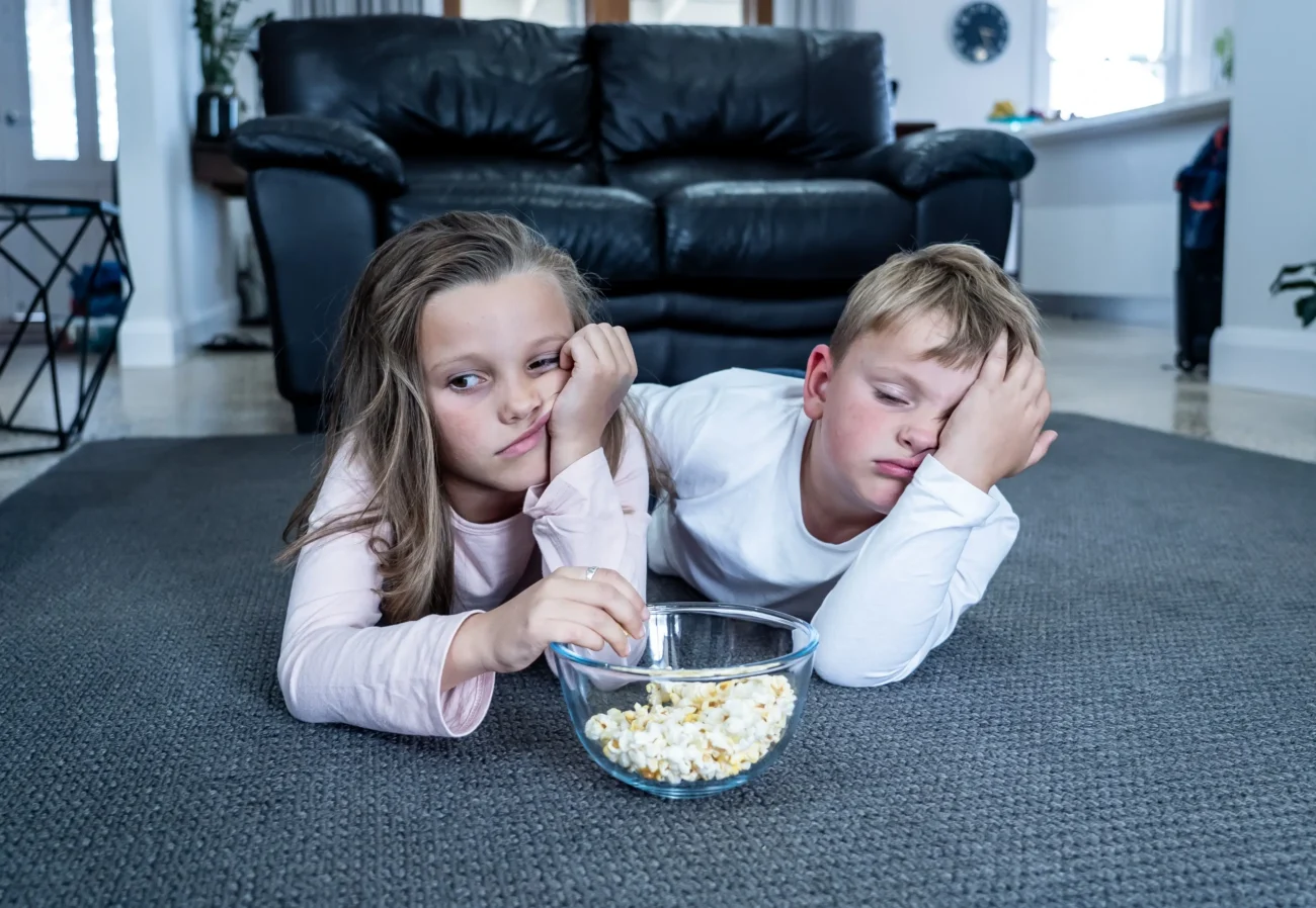 Dnešní děti jsou při sledování této pohádky znuděné. Zdroj: Shutterstock | TVGURU.cz Dvě děti dívající se znudeně na televizi.