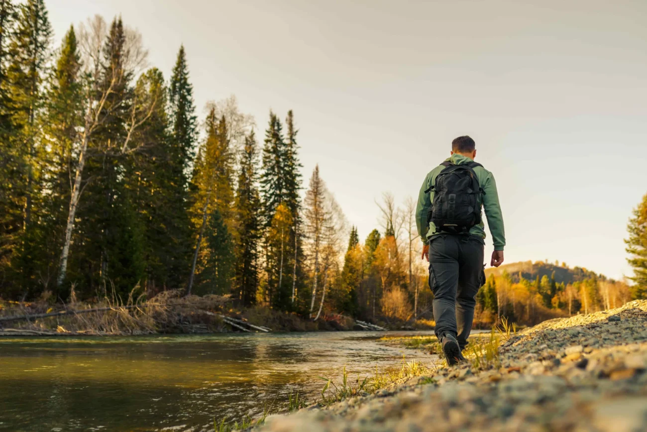 Při hledání vltavínů je často nutné povolení. Zdroj: Shutterstock | TVGURU.cz Muž chodící kolem řeky.
