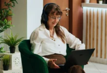 Žena sedící v křesle s počítačem.