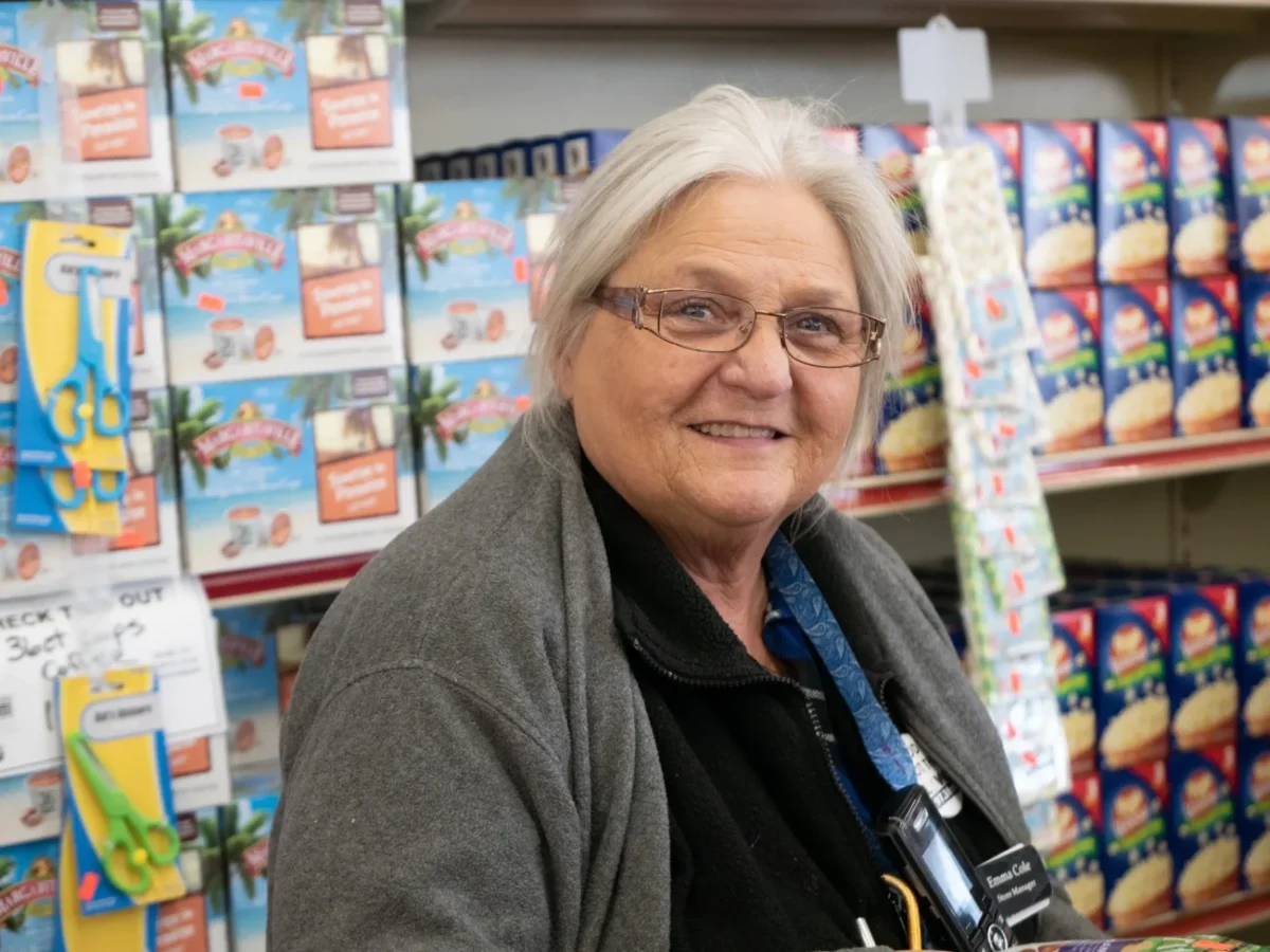 Stará paní se usmívá v obchodě.