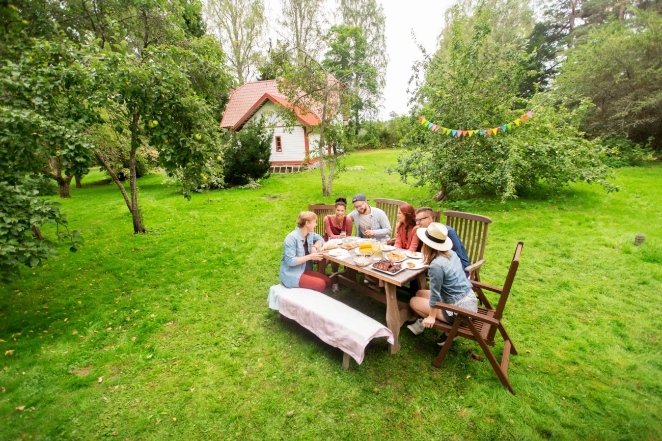 shutterstock_487886173-2 | TVGURU.cz Lidé venku sedí u stolu a jedí.