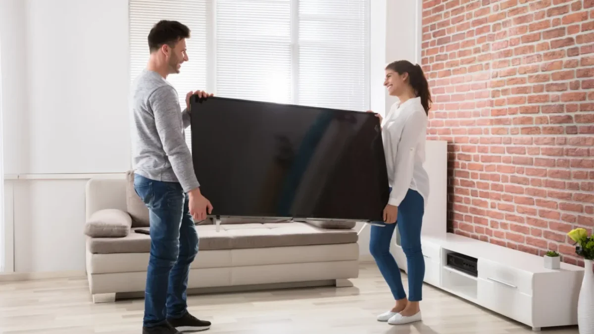 muž se ženou nesou televizi