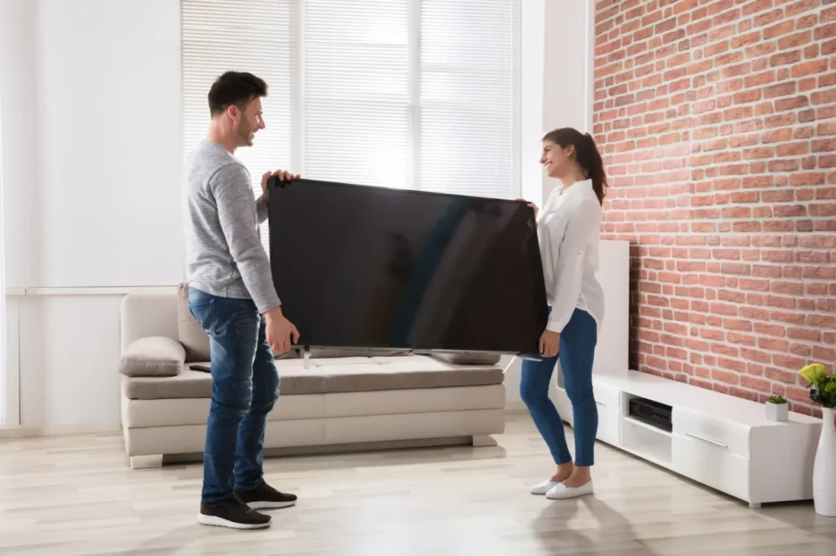 muž se ženou nesou televizi