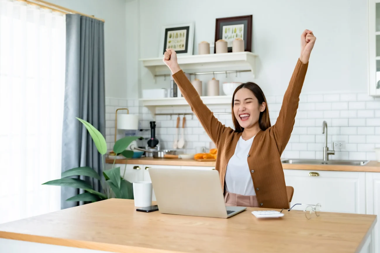 Pocit úspěchu toto znamení ucítí na vlastní kůži. Zdroj: Shutterstock | TVGURU.cz Radující se žena u počítače s rukama nad hlavou.