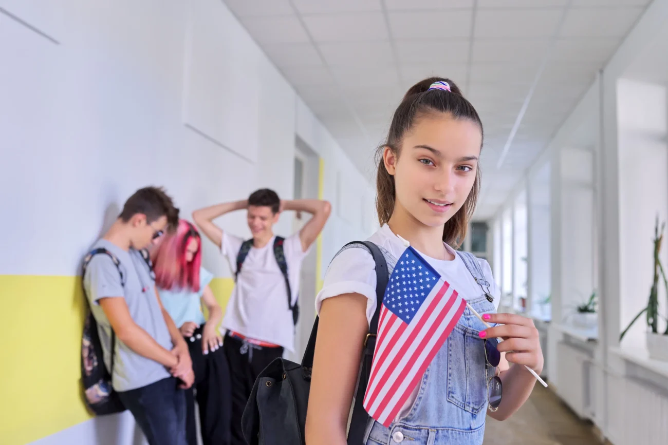 shutterstock_1864693087-2 | TVGURU.cz Holčička je ve škole a drží americkou vlajku.