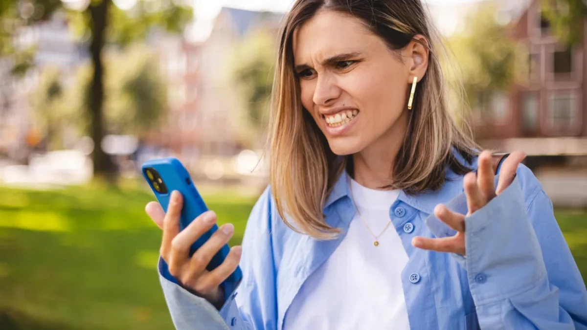 Žena naštvaně kouká do telefonu.