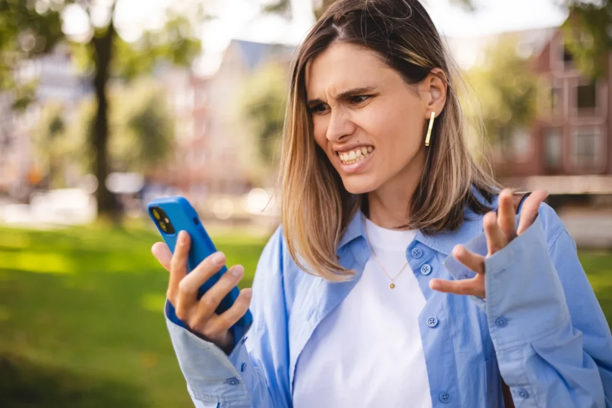 Žena naštvaně kouká do telefonu.