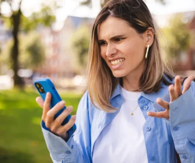 Žena naštvaně kouká do telefonu.
