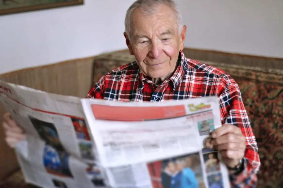 starší muž čte noviny