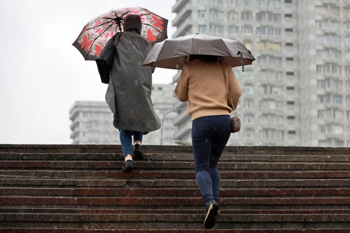 Lidé jsou s deštníky v ruce po schodech.