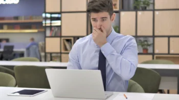 Muž s udiveným výrazem kouká do notebooku.