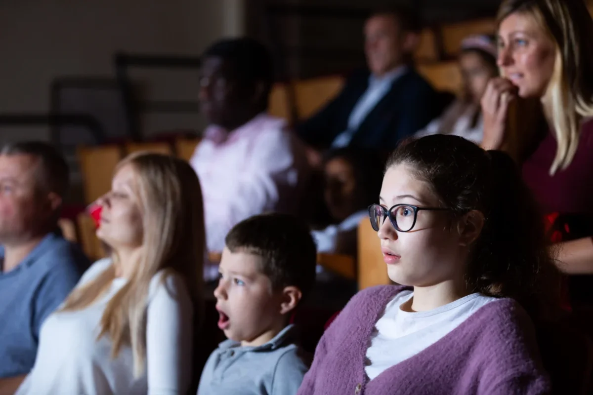 Lidé v kině nevěřícně zírají.