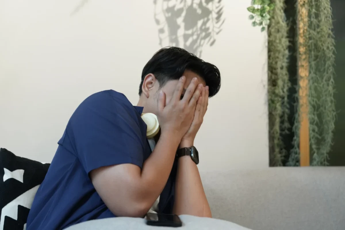 Vyděšený muž si zakrývá oči.