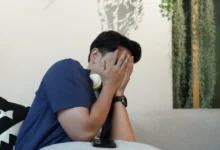 Vyděšený muž si zakrývá oči.