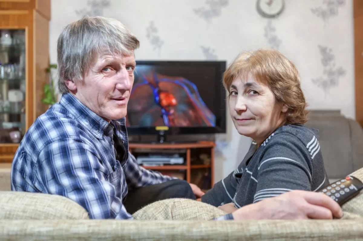 Muž a žena sedí na gauči u televize.