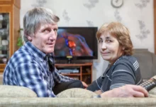 Muž a žena sedí na gauči u televize.