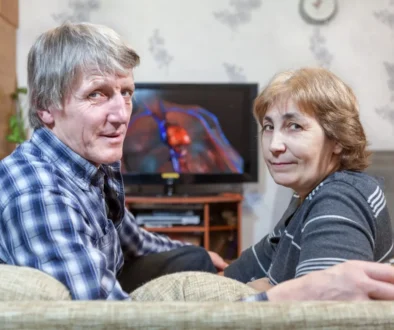 Muž a žena sedí na gauči u televize.