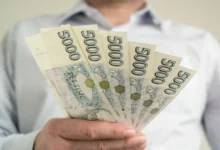 muž drží v ruce pětitisícové bankovky