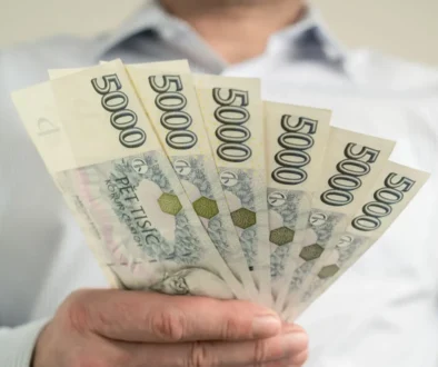muž drží v ruce pětitisícové bankovky