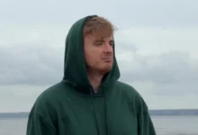 Muž má na hlavě kapuci a tváří se ustaraně.