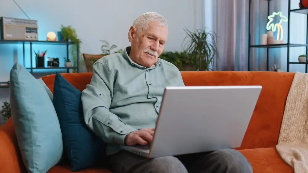shutterstock_2317955759_769255444519 | TVGURU.cz Starší muž sedí s notebookem